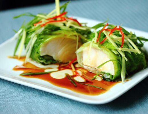Steaming is one of the best ways to cook delicate and lean fish such as halibut, sea bass, and hake. Here, halibut marinated with Shaoxing wine and grated ginger is wrapped and steamed in savoy cabbage leaves.