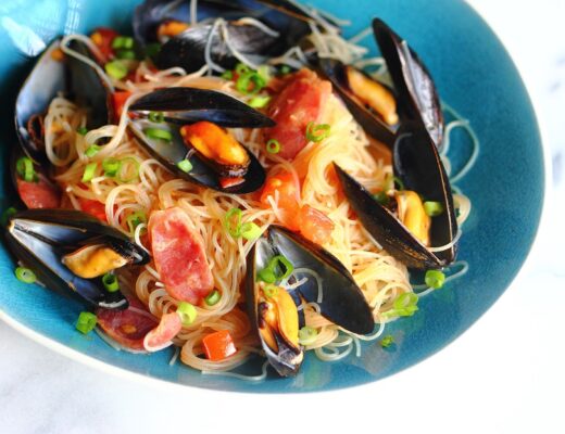 There are many exciting ways to cook mussels, beyond the familiar French-style steamed mussels. Here, mussels, Chinese sausage, rice noodles, and tomatoes create a simple and exciting one-dish meal.