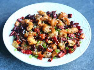 In this stunning dish from Sichuan, the chilies and peppercorns lend their wonderful aromas to the fried chicken pieces while giving them a gentle heat and a subtle tingling effect.